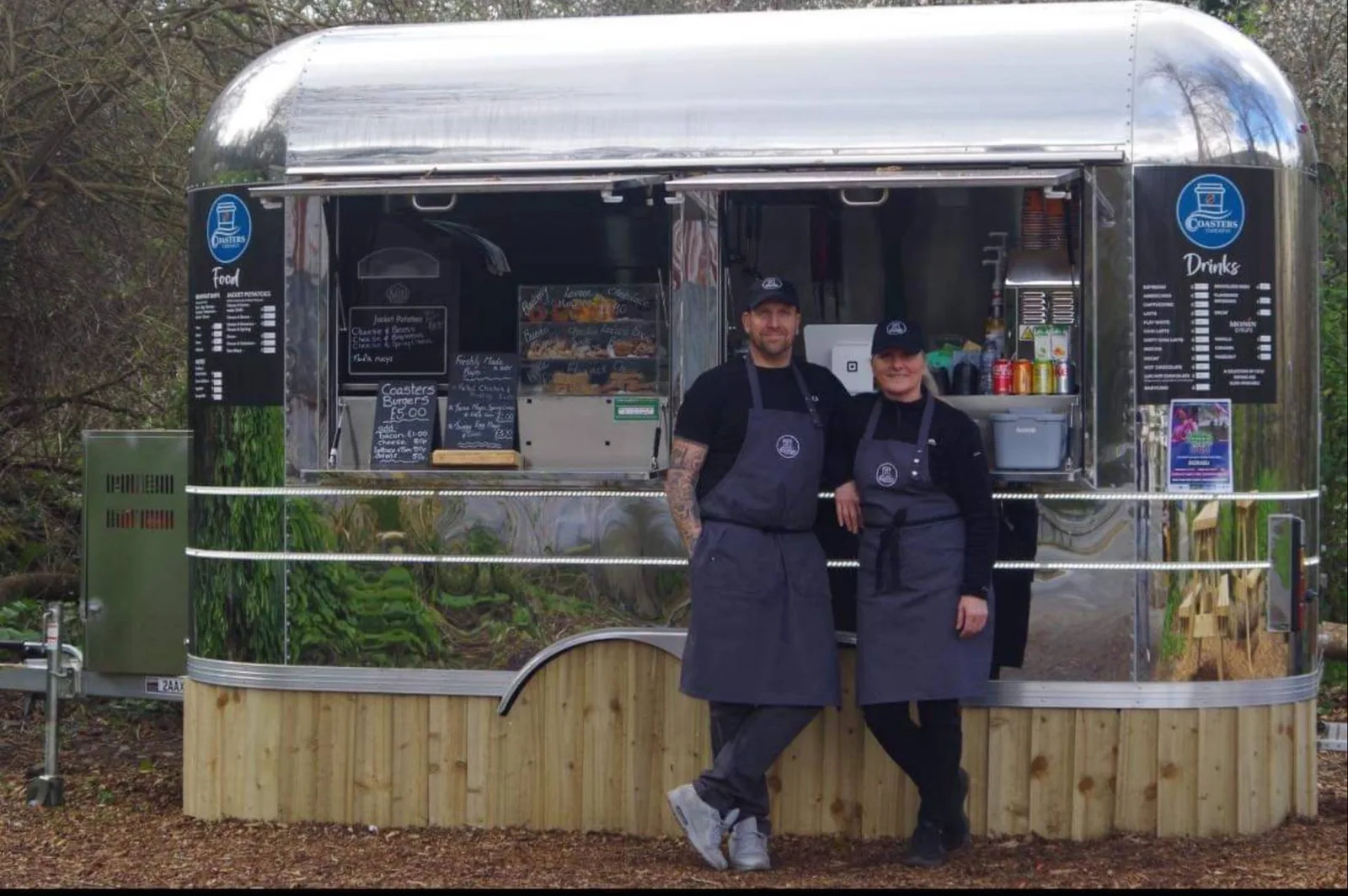 Two Coasters operators standing at the serving hatch of the branded Airstream